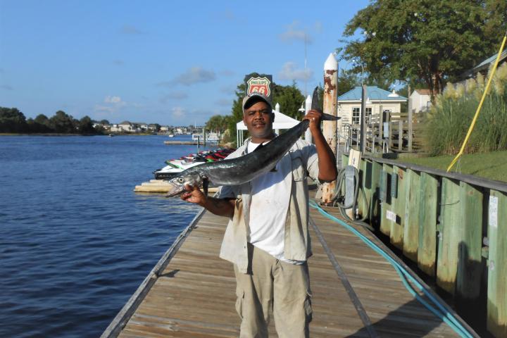 a man standing next to a body of water